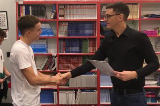 Učenik dobija diplomu od profesora